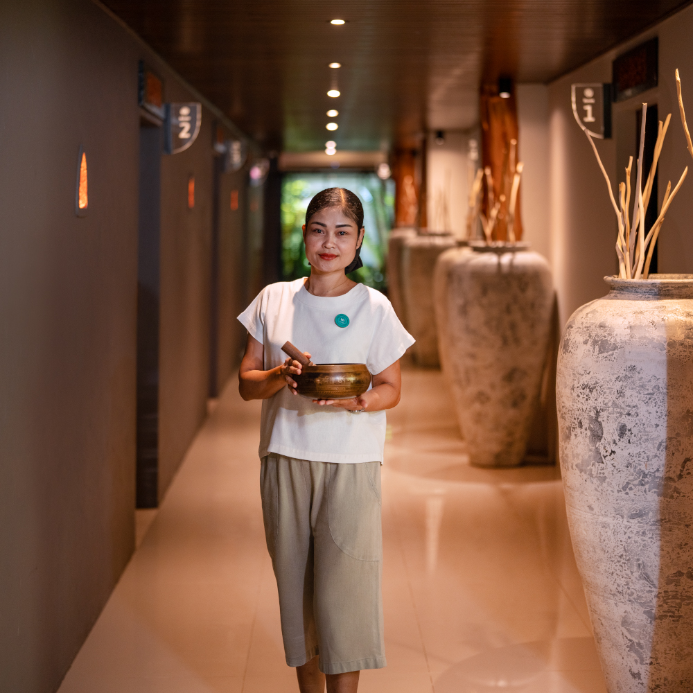 an experienced and certified therapist is standing with a sound bowl, ready to treat the customer at Amla Aqua - Organic spa & hydrotherapy in Cherngtalay, Phuket